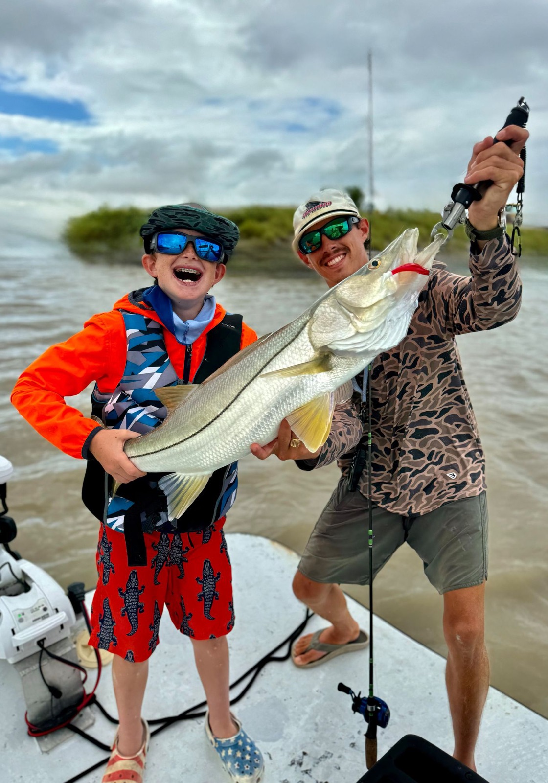 Young angler and Capt. Trevor Kucia holding up a big snook