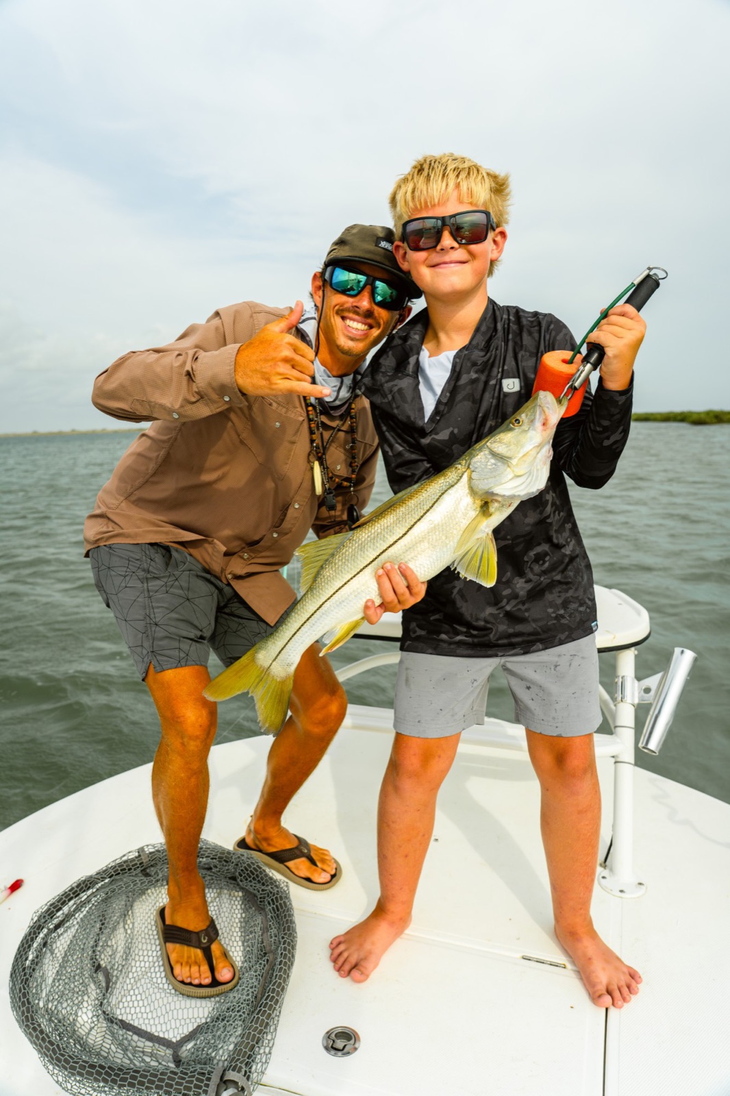 Capt. Trevor Kucia and a young angler with a snook on the bow