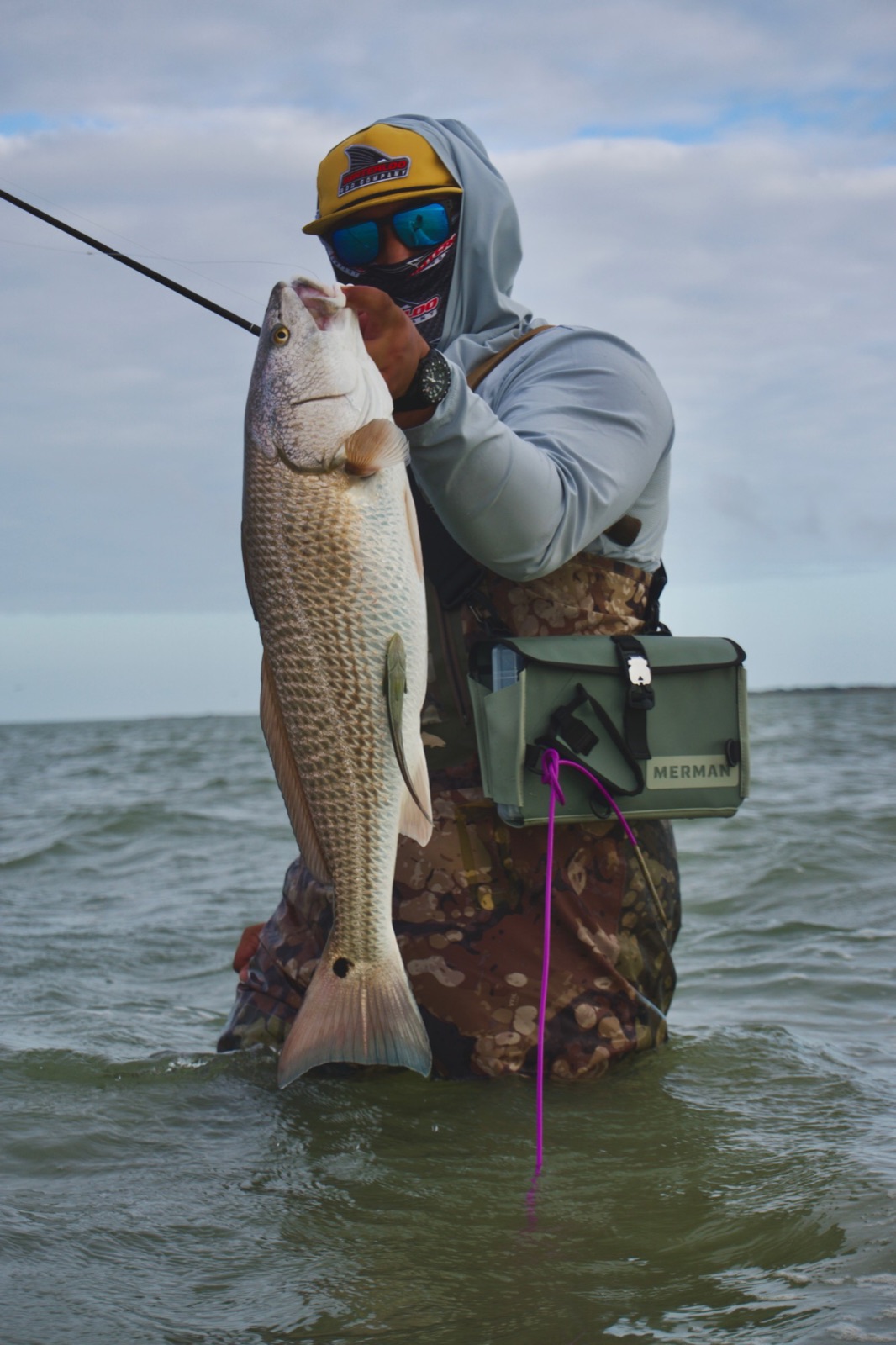 Wade fisherman holding a big redfish