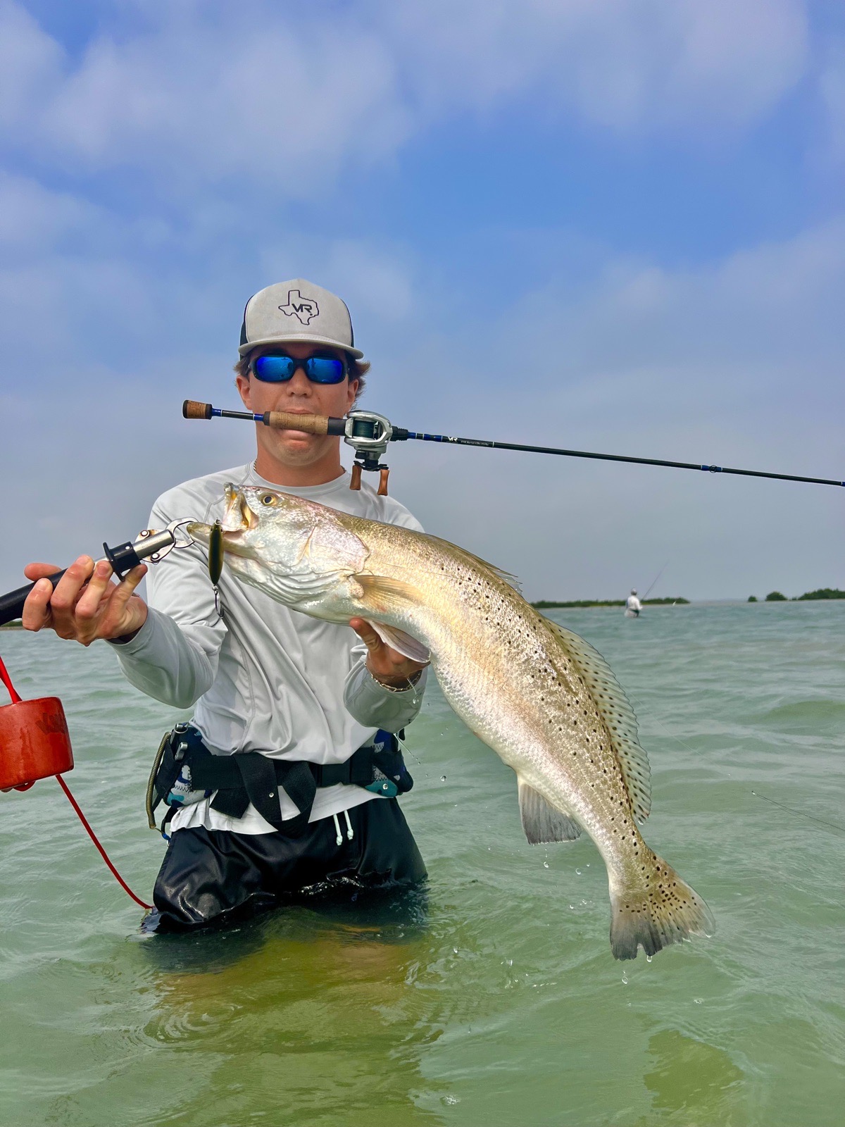 Angler wading with a big speckled trout