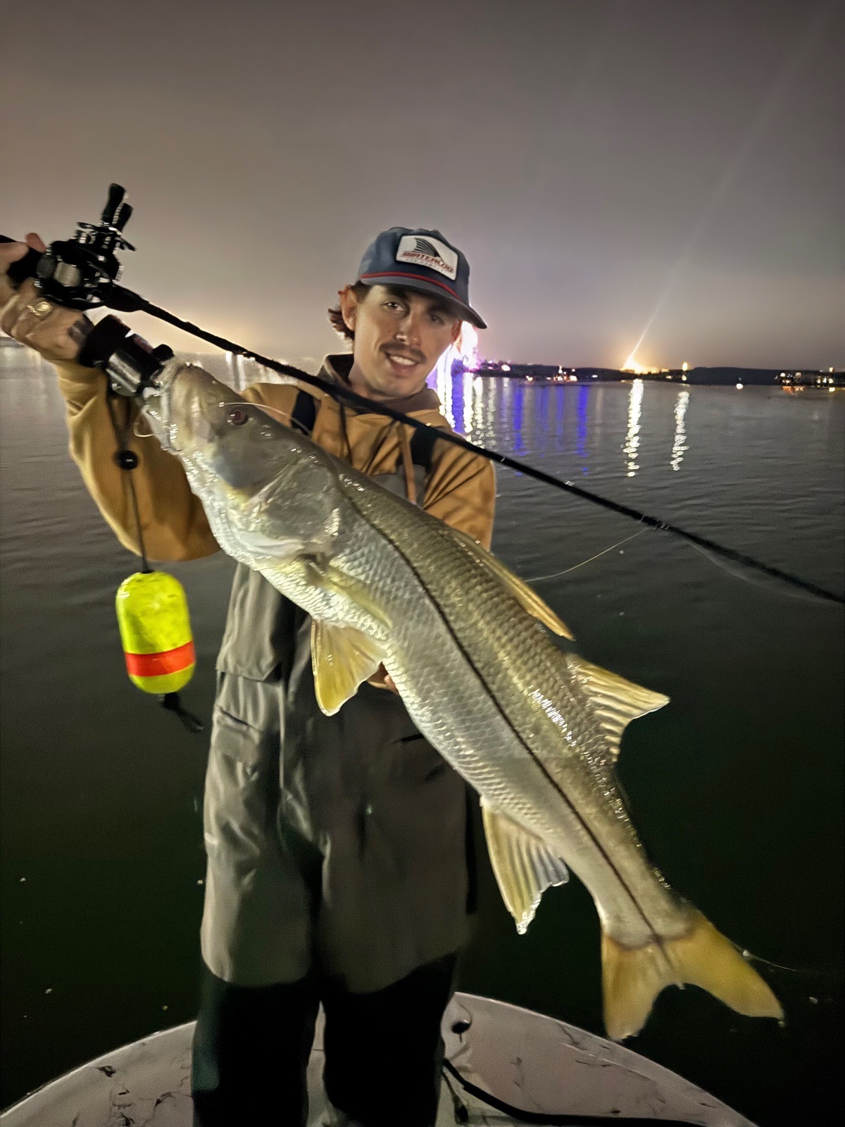 Angler holding a snook at night
