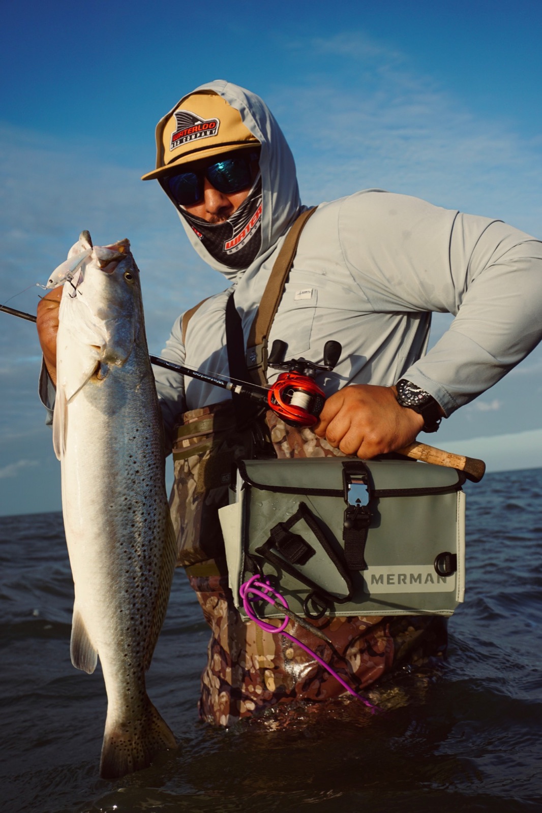 Hooded wade fisherman with a speckled trout