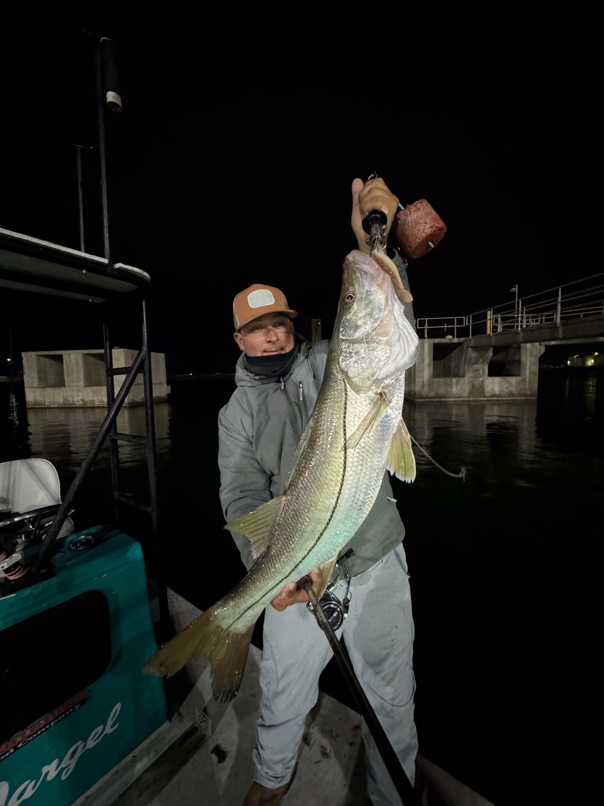 Angler showing off a snook at night