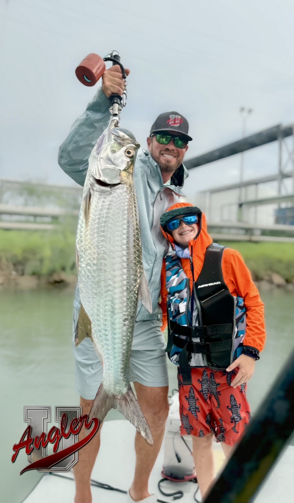 Young angler and his guide holding up a tarpon