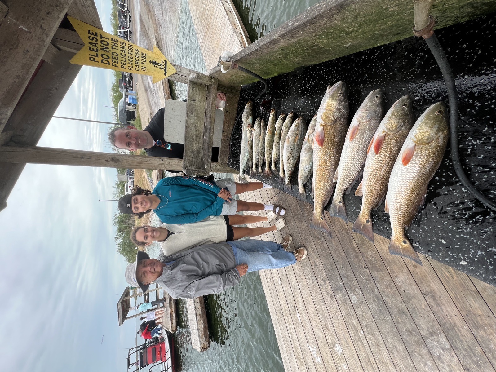 Family on the dock with a big catch of redfish